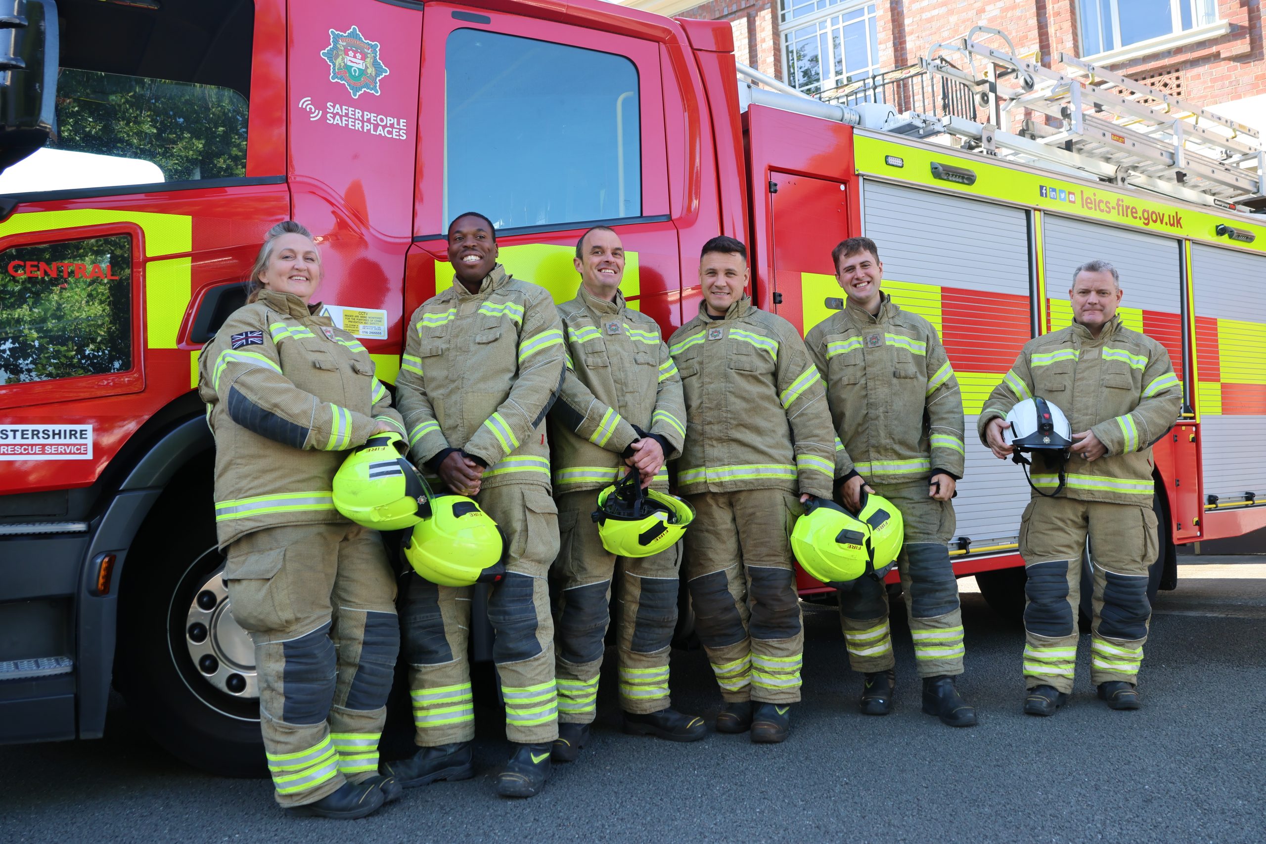 Image of Firefighters in their fire kit stood in front of a fire engine
