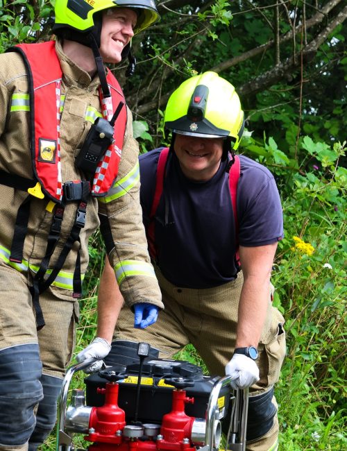 Image of two Firefighters working with equipment
